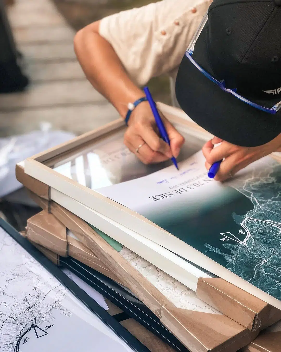 Personnalisation d’une affiche de course à la main – nom et chrono écrits sur papier d’art